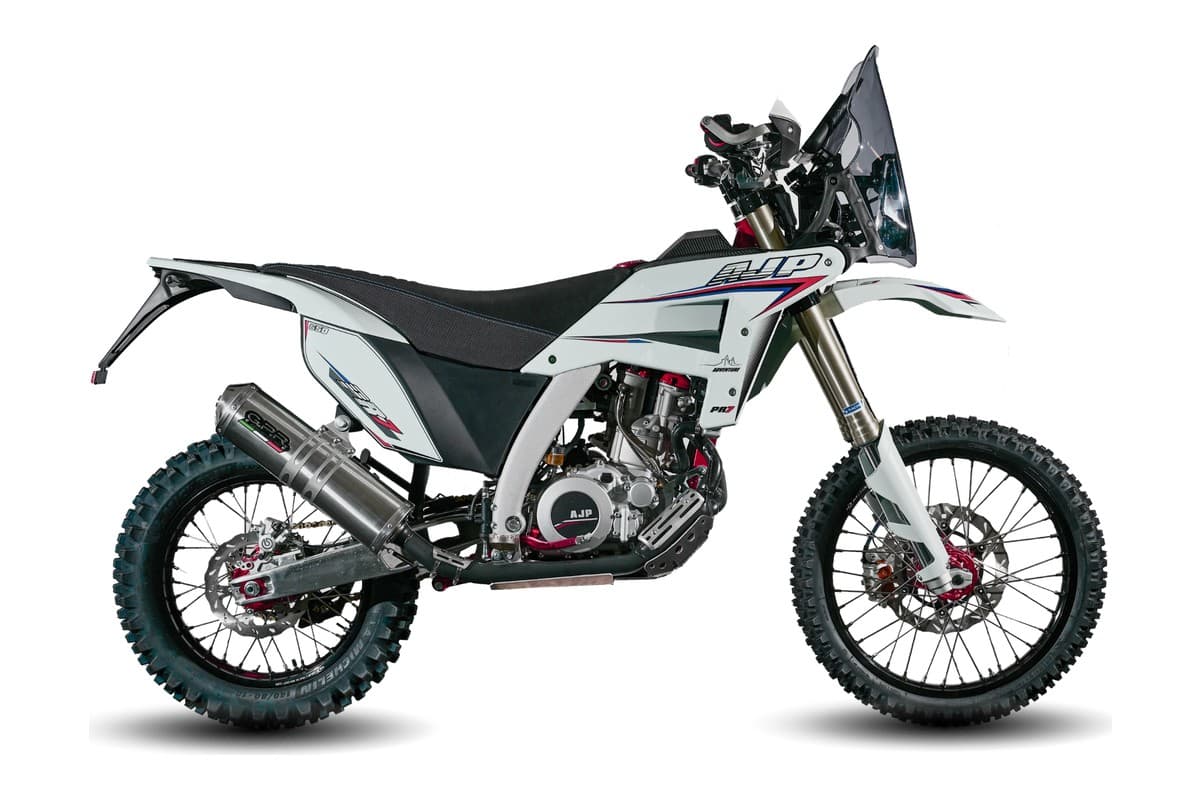 2027 AJP PR7 dual-sport motorcycle in white with red and blue accents, right-side studio profile showing spoked wheels and rally-style headlight cowl