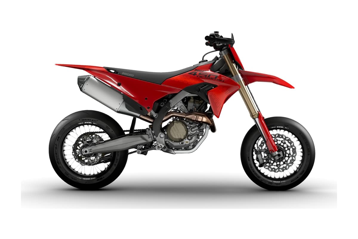 2027 Ducati Desmo450 SM competition supermoto in Ducati Red, right-side studio profile showing the gold Showa fork, spoked 16.5-inch front and 17-inch rear wheels on slick tires, and the aluminum silencer