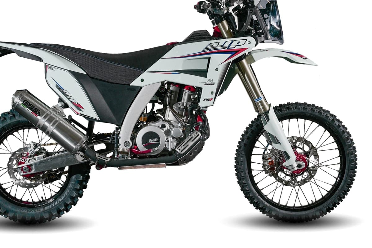 AJP PR7 close-up on rear three-quarter angle, showing the GPR exhaust, tubular frame cradle and knobby Michelin tires