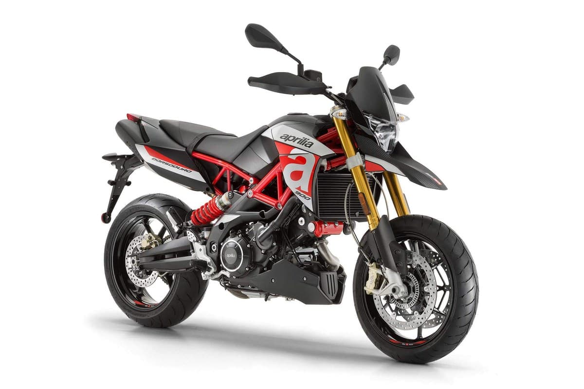 Aprilia Dorsoduro 900 front three-quarter studio view highlighting the red trellis frame, LED-style headlight and upswept tail section