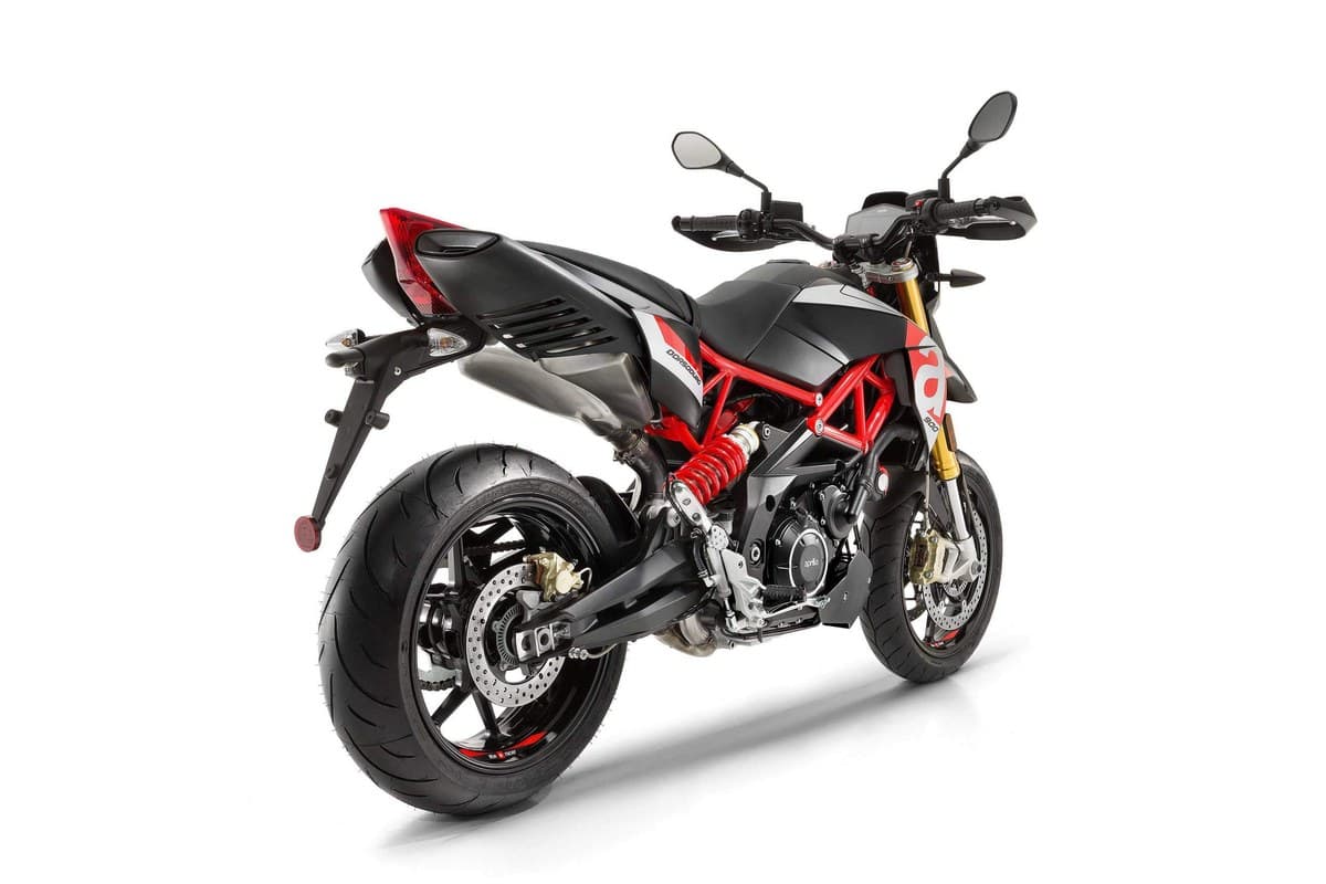Aprilia Dorsoduro 900 rear three-quarter studio shot showing the red rear shock, exposed engine and stacked dual mirrors