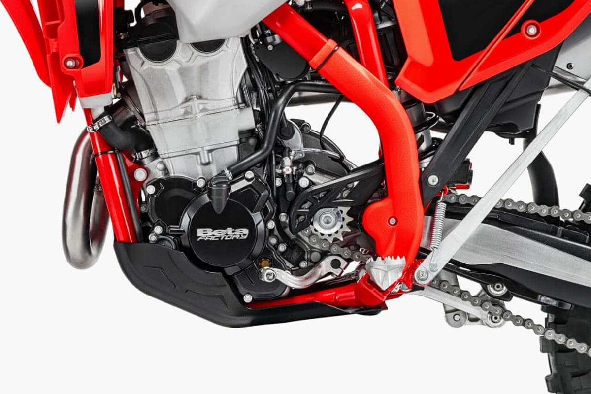 Close-up of the Beta 350 RR X-Pro engine bay showing the silver crankcase, red frame tubes, skid plate and chain drive