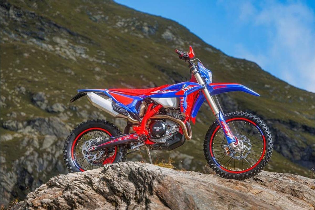 390 RR Race left-side view perched on a rocky outcrop, showing the WP fork, red frame rails and white number plate