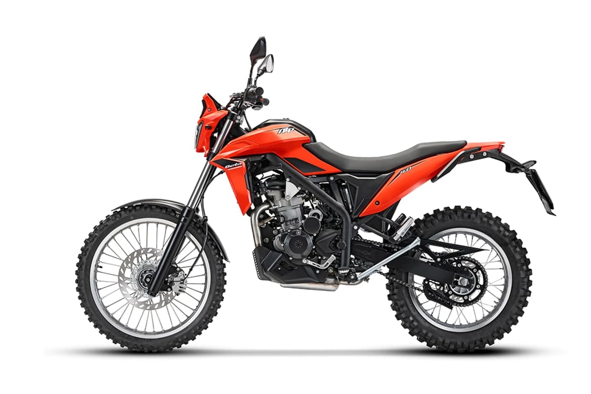 Beta Alp 4.0 in red, left-side studio profile on white showing the chain and rear sprocket, black swingarm and underslung exhaust header