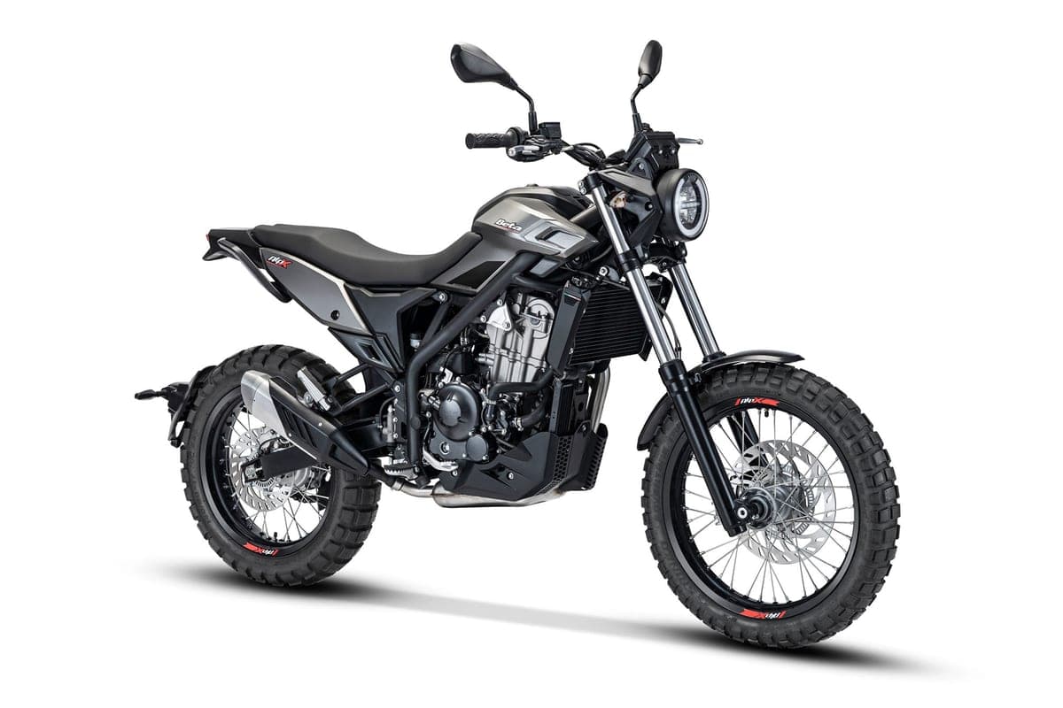 Beta Alp X front three-quarter studio view in gunmetal grey, showing the round headlight, upside-down forks and exposed engine cooling fins