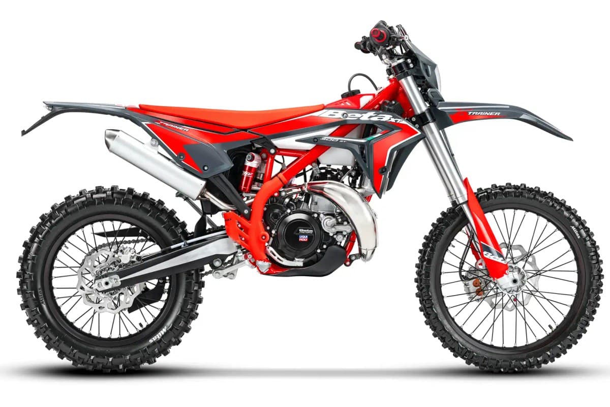 Beta Xtrainer 300 Lowboy rear three-quarter studio shot showing the red frame, twin exhaust silencer and knobby off-road tires