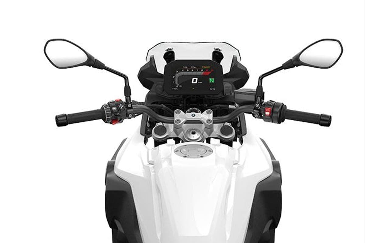 BMW F 800 GS cockpit close-up showing the TFT instrument display, adjustable handlebar, mirrors and white tank between the rider's knees