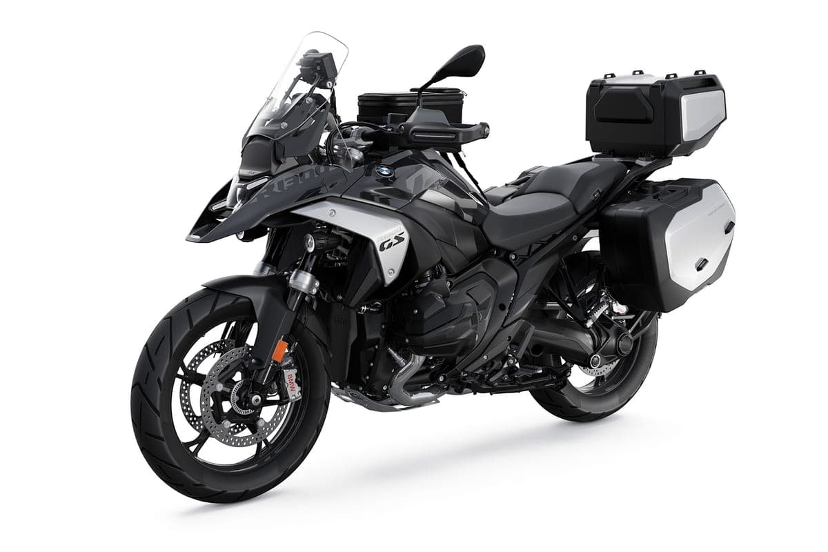 BMW R 1300 GS in matte grey camouflage paint fitted with a full luggage system, rear three-quarter studio view showing the top case and side panniers