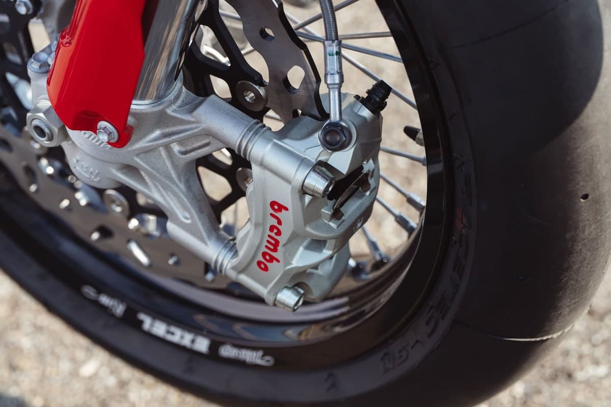Close-up of the Desmo450 SM's Brembo Stylema radial front caliper on the Galfer floating disc, beside the spoked Excel rim and slick tire