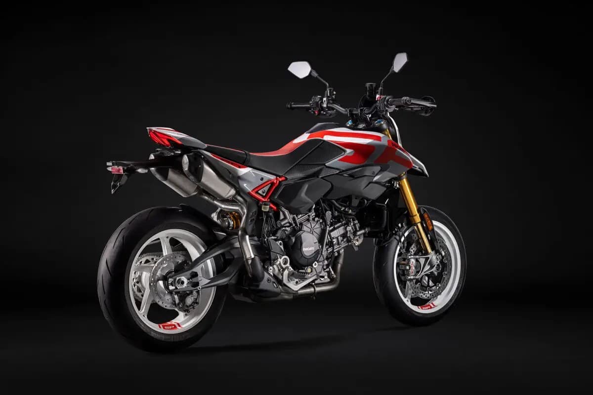 Ducati Hypermotard V2 SP rear three-quarter studio view highlighting the twin underseat exhausts, gold forks and red trellis subframe