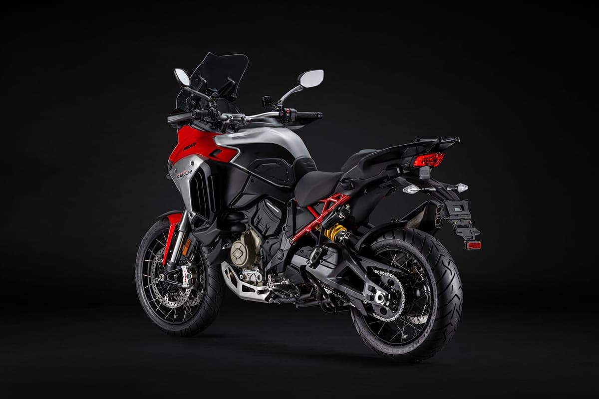 Multistrada V4 Rally rear three-quarter studio shot on black background highlighting the red trellis frame, gold-tone engine cases and single-sided swingarm shock