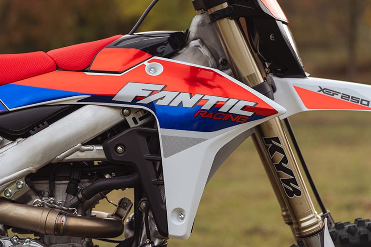 Fantic XEF 250 TL side shrouds and radiator area with Fantic Racing decal, red seat and gold KYB fork leg outdoors