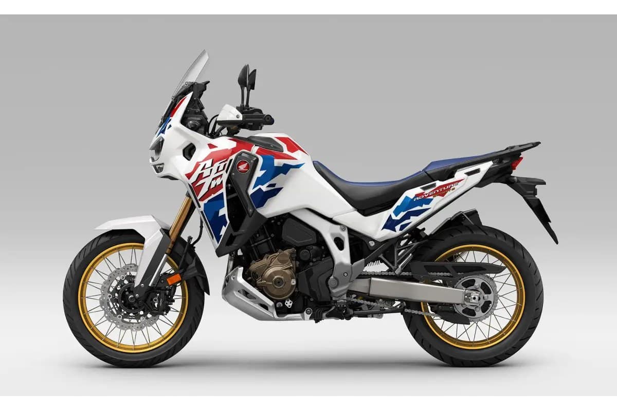 Honda Africa Twin Adventure Sports ES in white with red and blue tricolor graphics, right-side studio profile with gold-rimmed spoked wheels and twin headlights
