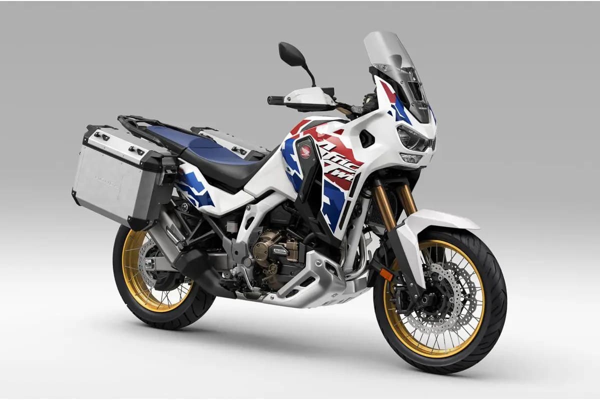 Africa Twin Adventure Sports ES in tricolor livery, front three-quarter studio view with aluminum side panniers, gold forks and tall adjustable windscreen