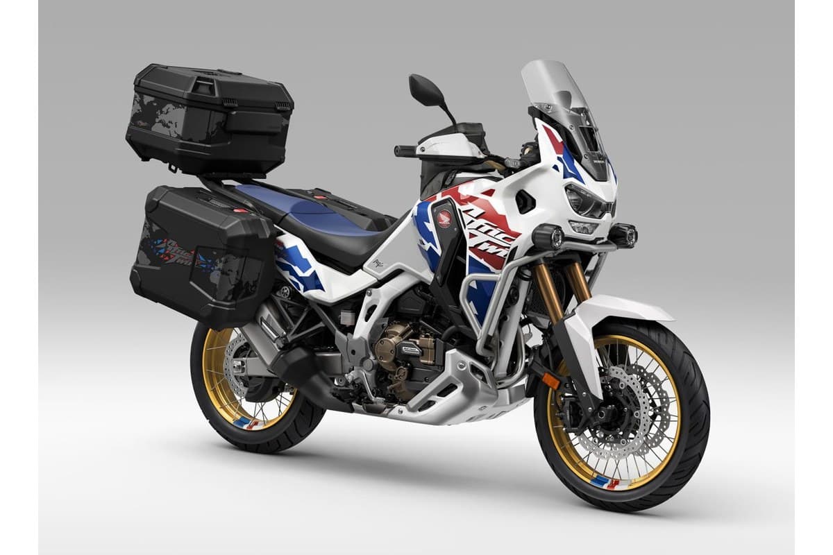 Africa Twin Adventure Sports ES in tricolor paint fully loaded with top box and side cases, front three-quarter studio shot showing LED headlight and crash bars