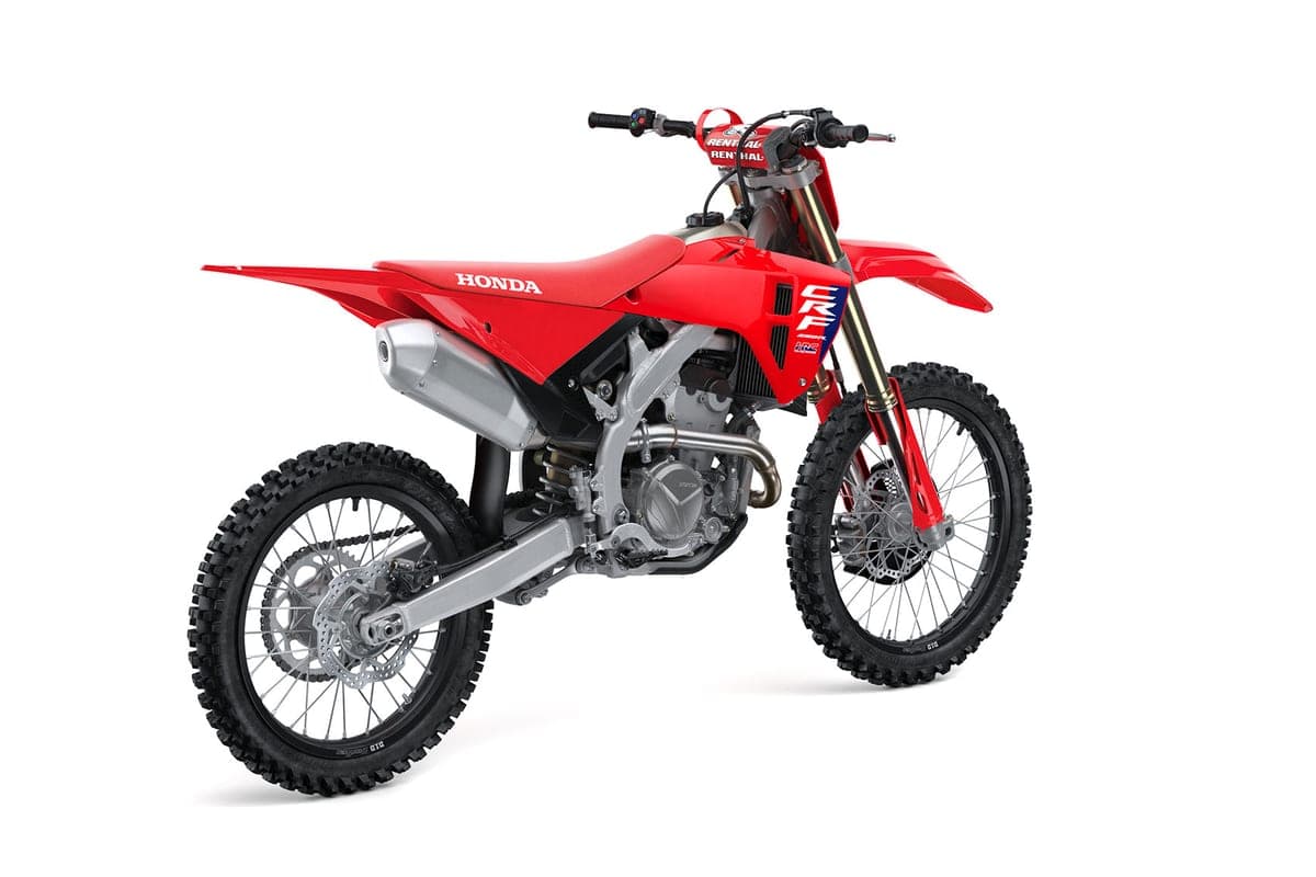 Honda CRF250R rear three-quarter studio shot highlighting the silver muffler, chain, and Renthal handlebars