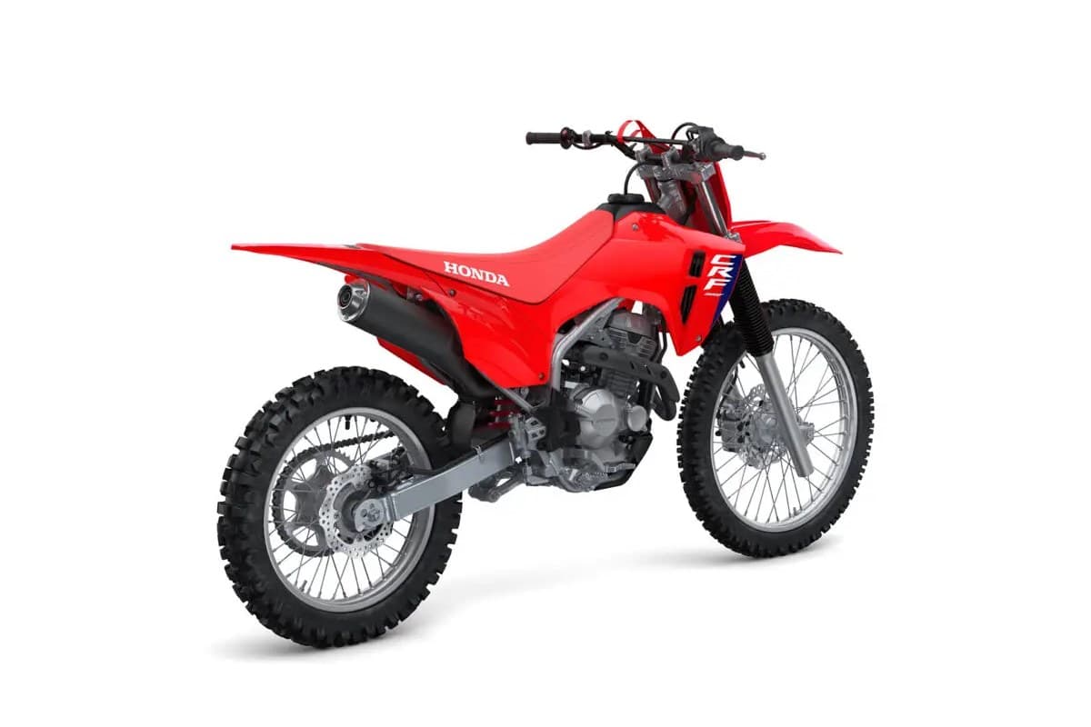 Honda CRF300F rear three-quarter studio view highlighting the tucked muffler, chain guard and knobby dual-sport tires