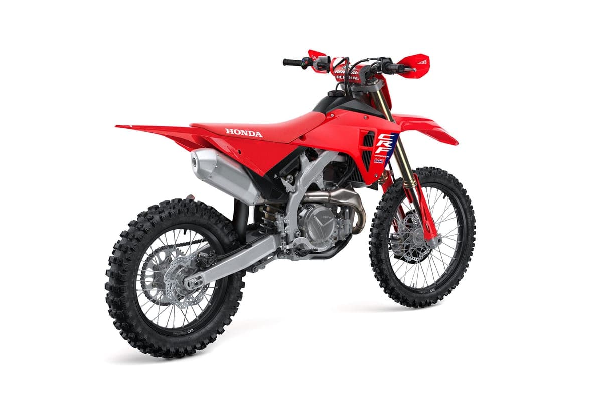 Honda CRF450RX rear three-quarter studio view highlighting the silver muffler, twin-spar frame and CRF graphics on the shrouds