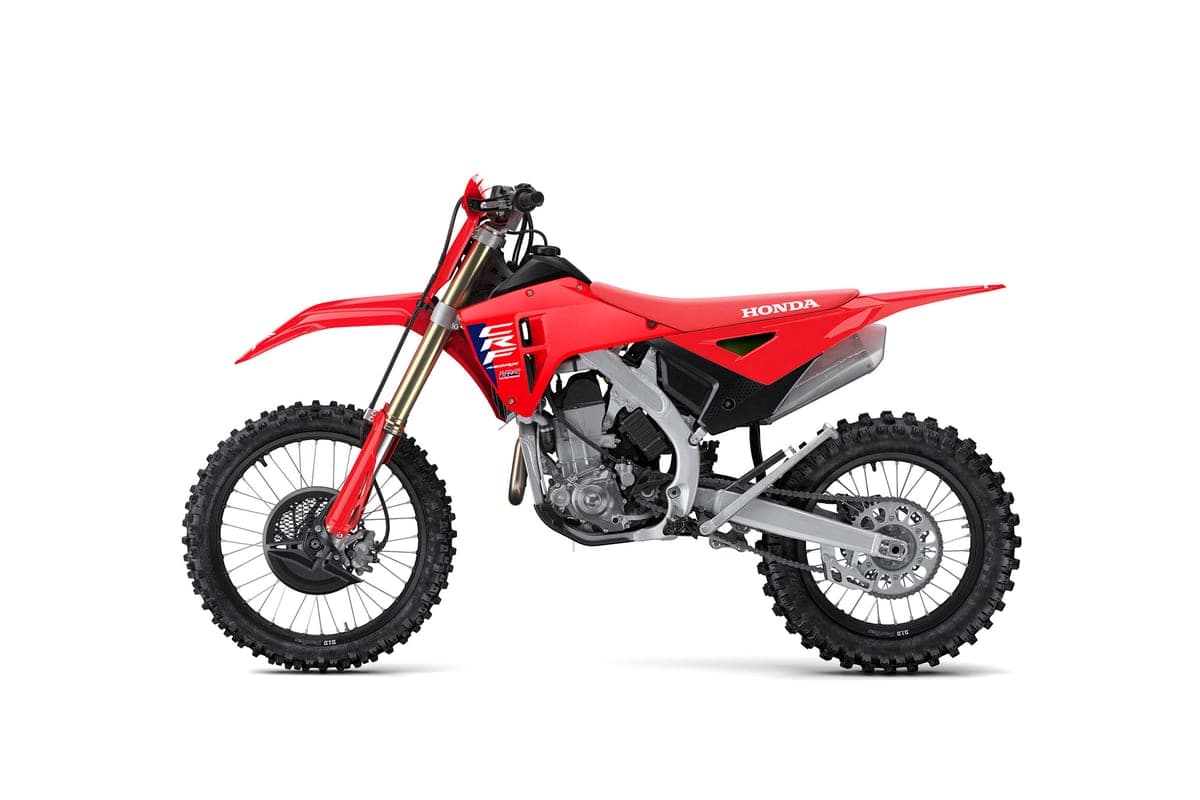 Honda CRF450RX left-side studio profile with red bodywork, gold forks and dirt-focused knobby tread front and rear