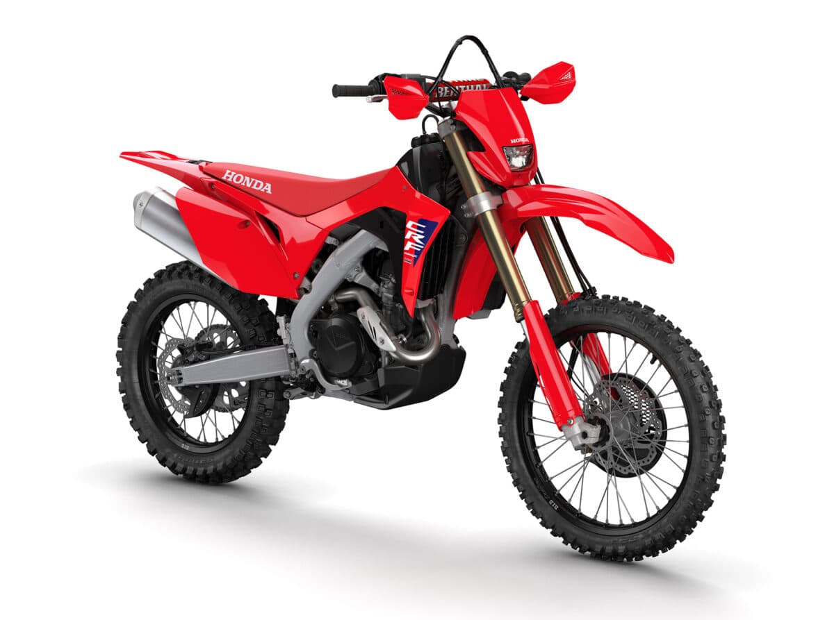 Honda CRF450X front three-quarter studio shot showing the LED headlight, gold forks, front disc brake and Renthal bar pad
