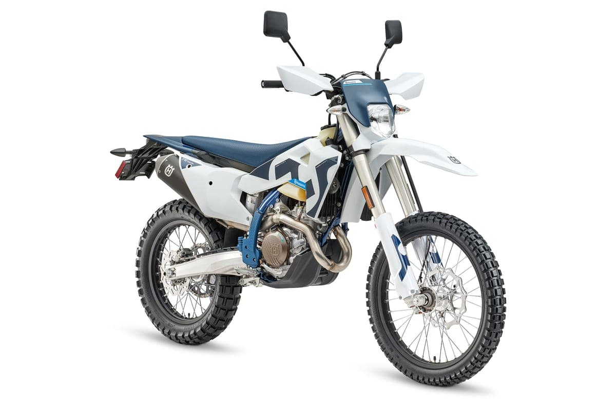 Husqvarna FE 501s front three-quarter studio view in white and navy, showing the LED headlight, handguards and radiator shrouds