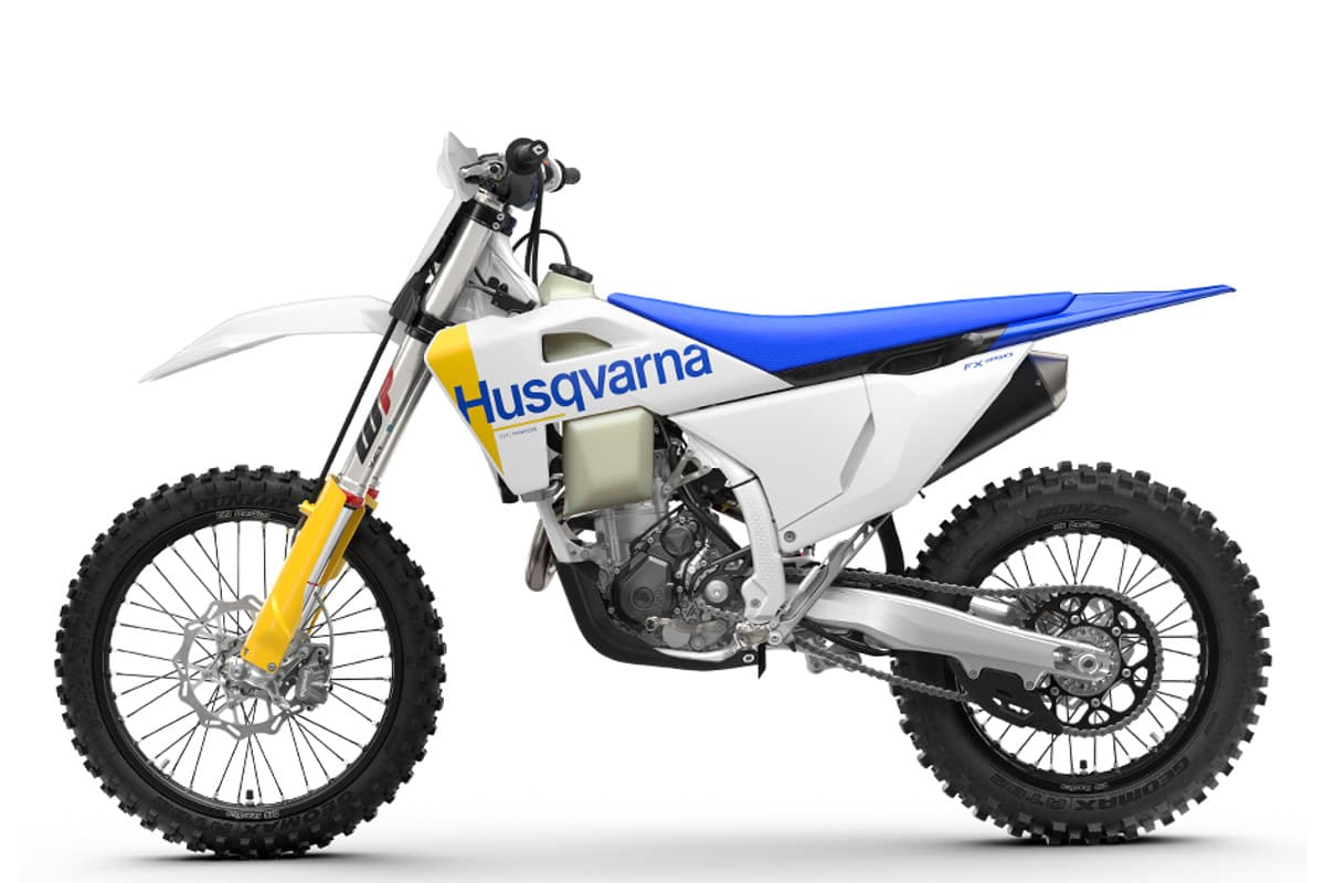 Husqvarna FX 350 left-side studio profile in white and navy blue, showing the exhaust muffler, spoked wheels and blue seat