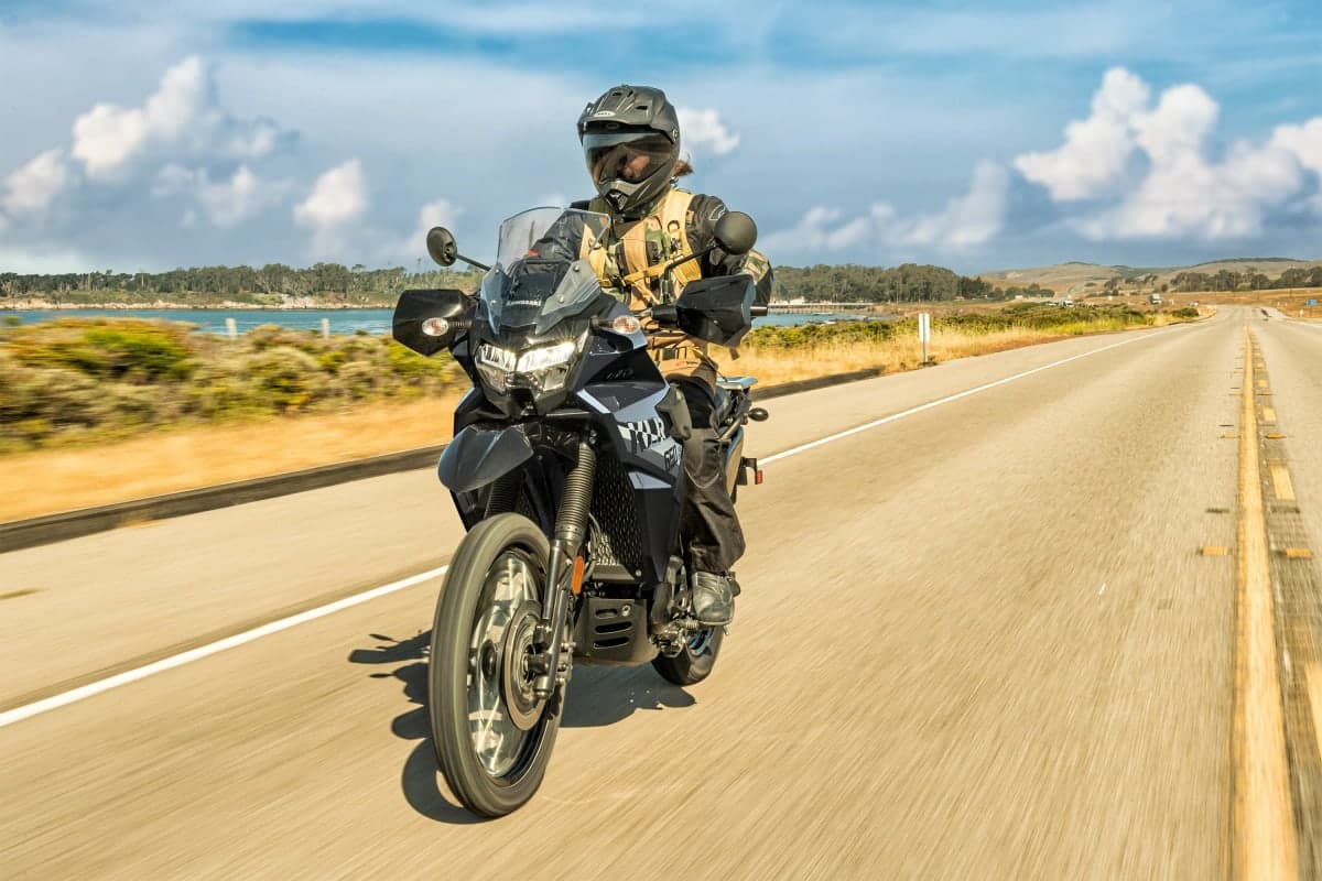 Rider on a KLR650 S on a straight coastal highway