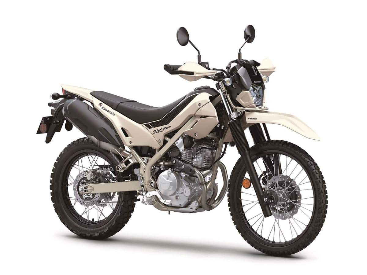 Kawasaki KLX230 Sherpa S ABS in cream, front three-quarter studio view showing the round LED headlight, hand guards and knobby dual-sport tires