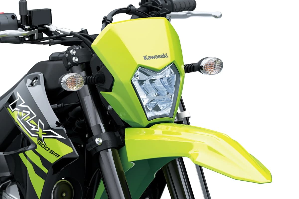 Close-up of the KLX300SM's LED headlight, turn signal and neon green front fender