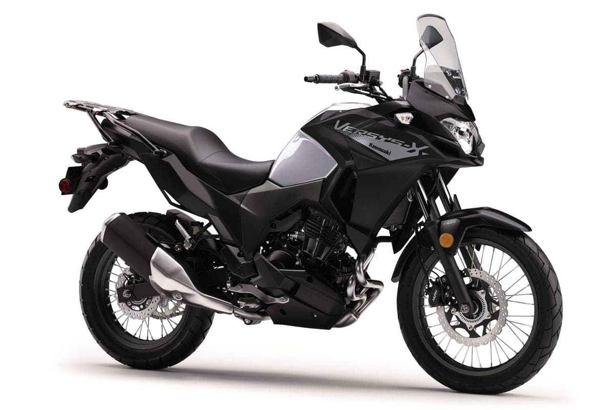 Kawasaki Versys-X 300 ABS in black and silver, rear three-quarter studio view highlighting the exhaust, spoked rear wheel and luggage rack