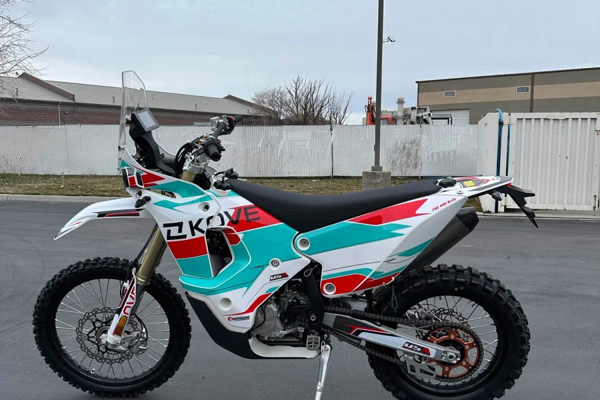 Kove 450 Rally parked outdoors in a lot, left-side view highlighting the rally windscreen, gold forks and knobby dual-sport tires