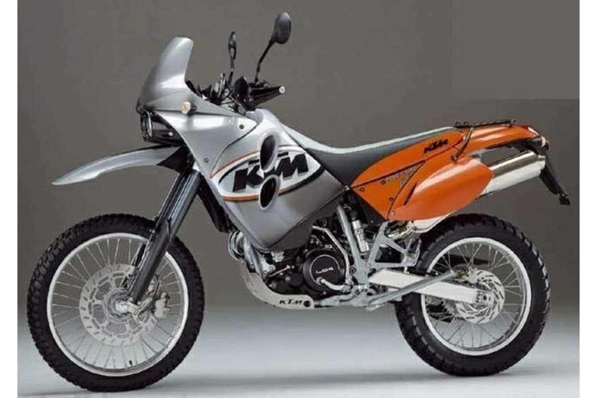 KTM 640 Adventure in silver and orange, front three-quarter view on a grey background highlighting the beak fender and twin round headlights