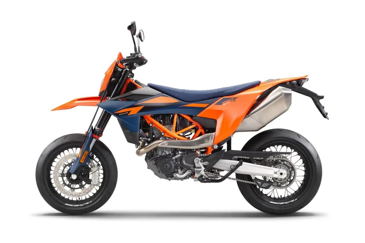 2026 KTM 690 SMC R in orange and blue, left-side studio profile showing the stainless header pipe, blue WP forks and floating front brake disc
