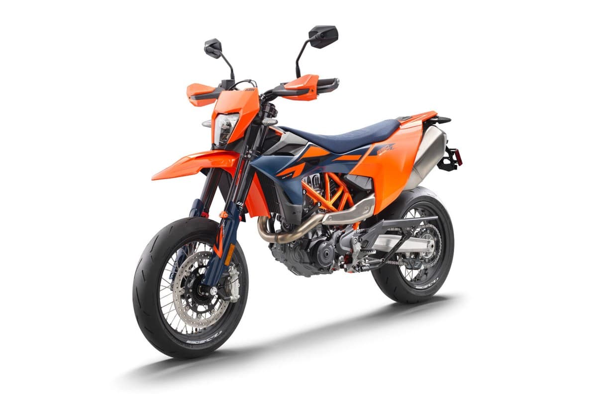 2026 KTM 690 SMC R in orange and blue, front three-quarter studio view showing the LED headlight, handguards and radial front brake