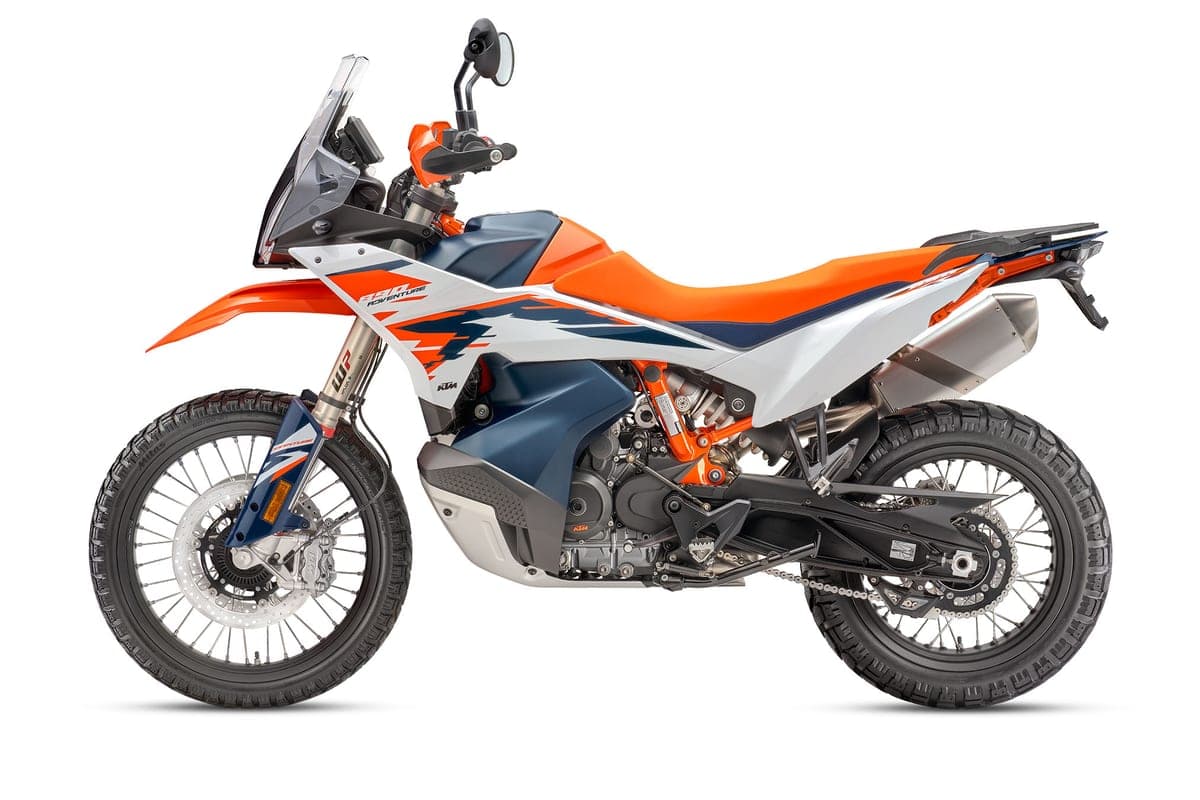 890 Adventure R left-side studio profile showing the tall windscreen, knobby tires and twin-pipe exhaust tucked high under the tail