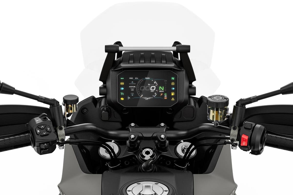 Close-up of the Moto Guzzi Stelvio cockpit with its TFT instrument display, handguards and switchgear framed by the windscreen