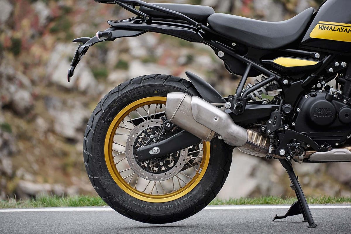 Himalayan 450 in black with yellow tank graphics, rear detail shot showing the gold-rimmed spoked wheel, upswept exhaust and rear shock