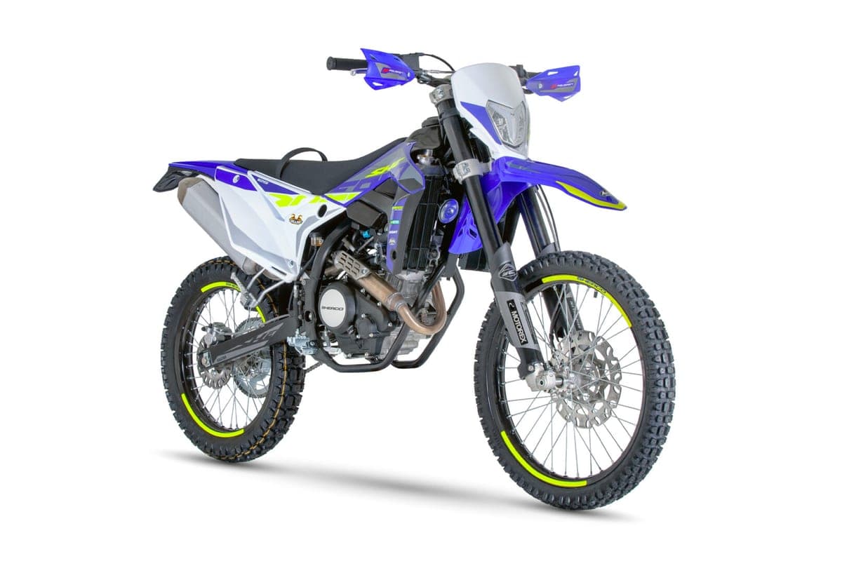 Sherco 125 4T SE-RS Factory, front three-quarter studio view highlighting the white headlight cowl, handguards and Motorex-branded forks