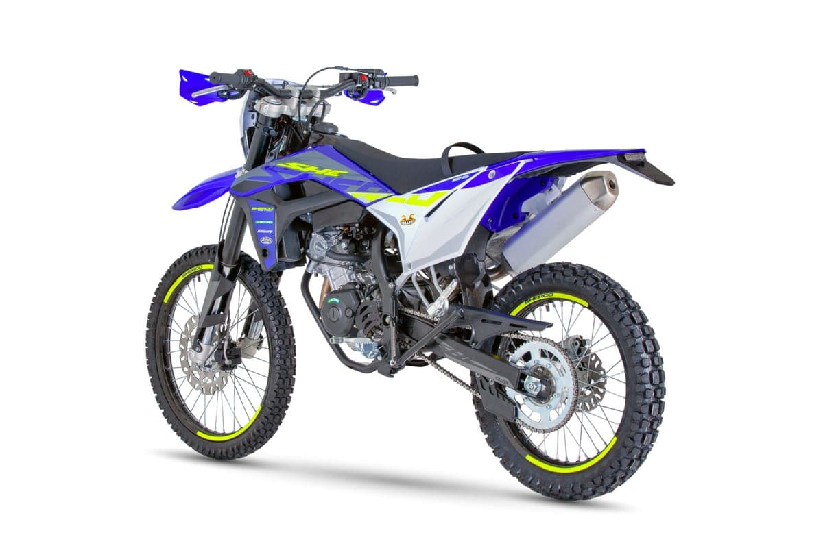 Sherco 125 4T SE-RS Factory rear three-quarter studio shot showing the upswept silver muffler, rear disc brake and sprocket