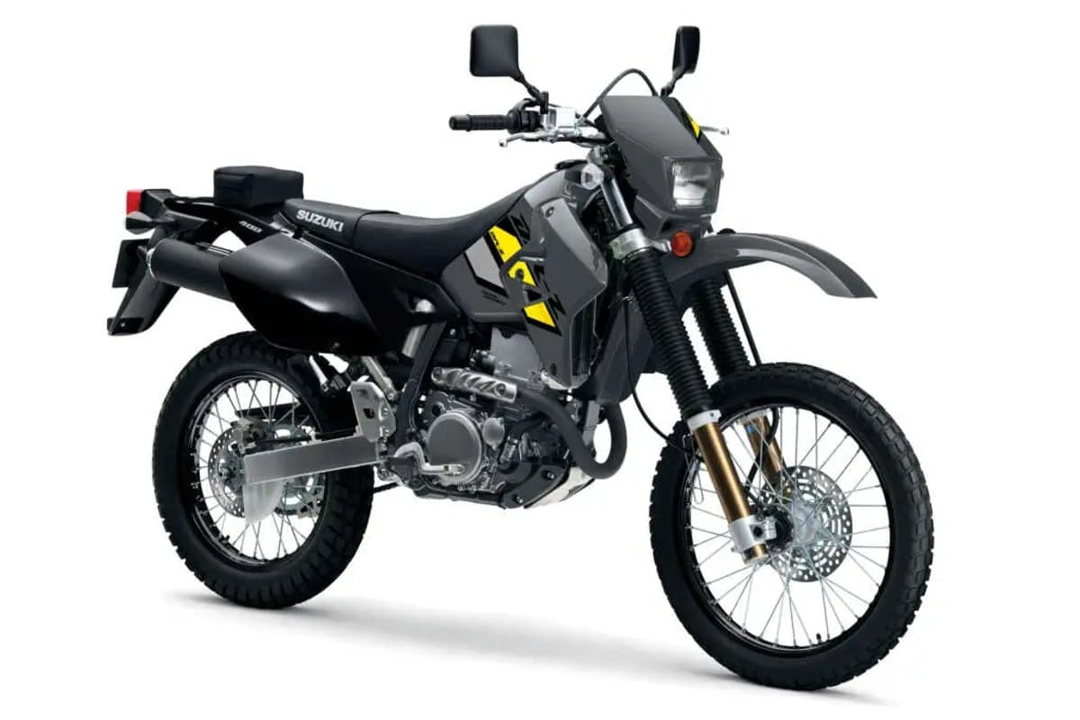 Suzuki DR-Z400S in black with yellow accents, front three-quarter studio view highlighting the round headlight, gold inverted forks and skid plate