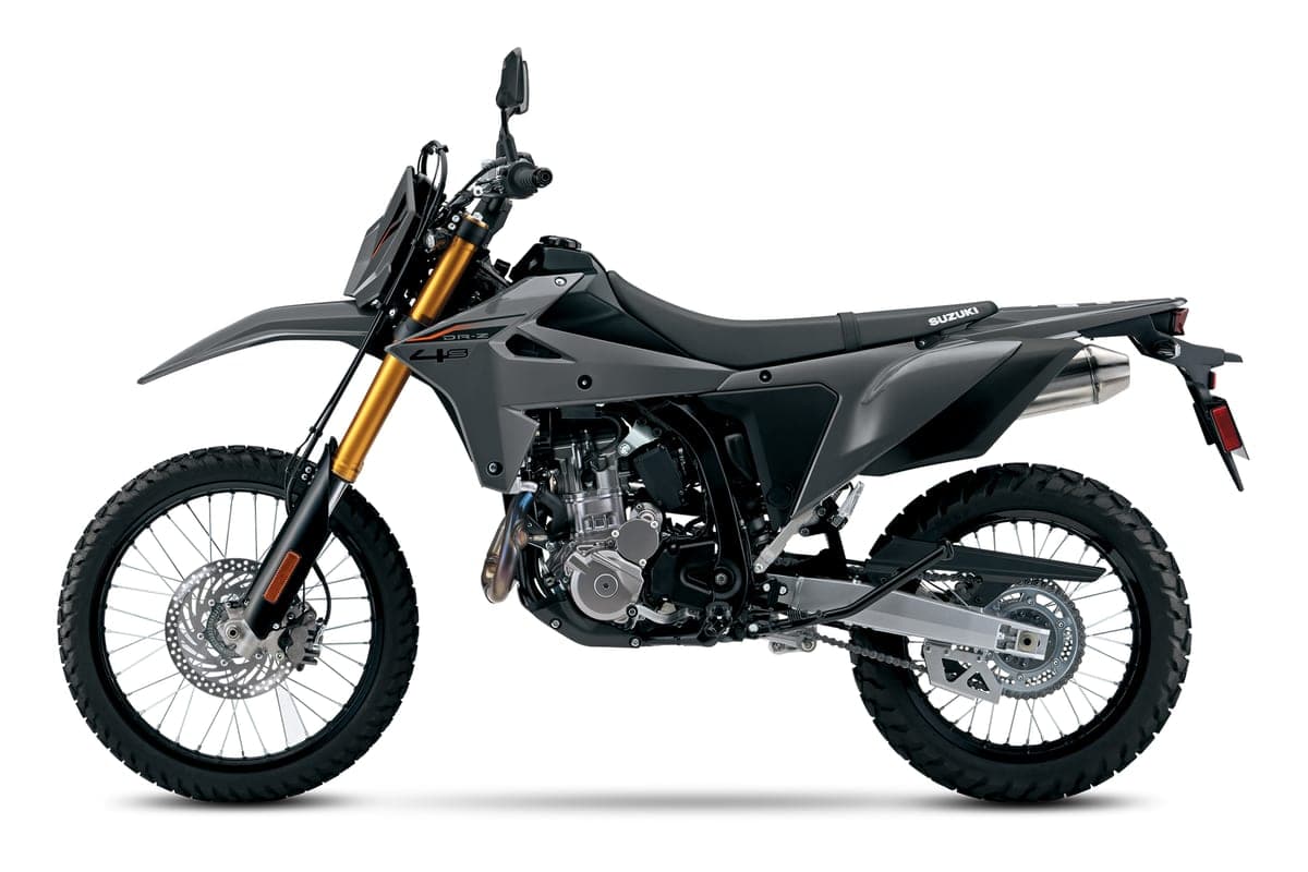 Suzuki DR-Z4S left-side studio profile in gray showing the gold forks, single front disc, chain drive and DR-Z 4S tank graphic