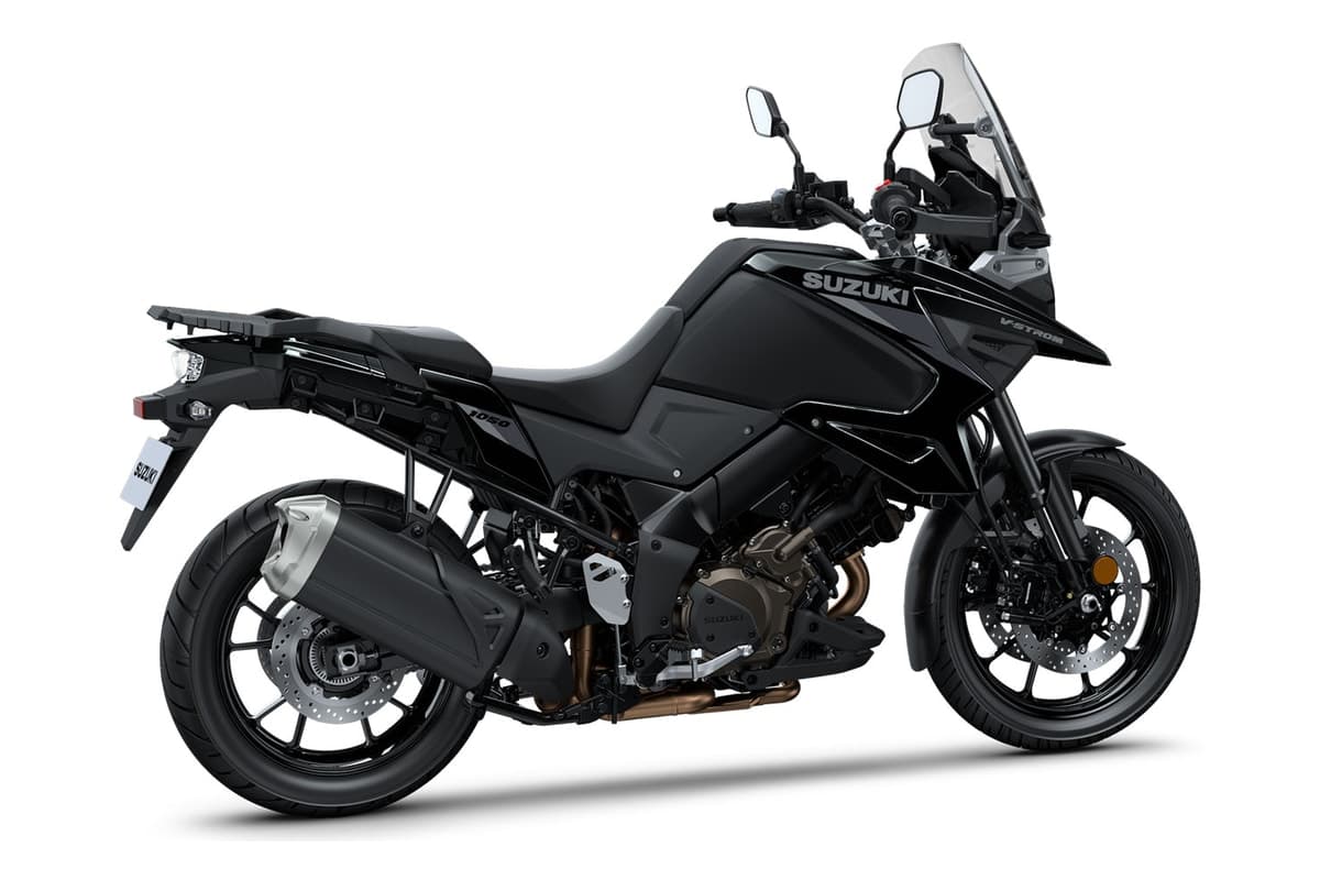 Suzuki V-Strom 1050 rear three-quarter studio view showing the exhaust, luggage rack and rear disc, in the 2026 black livery with grey rather than red Suzuki logos