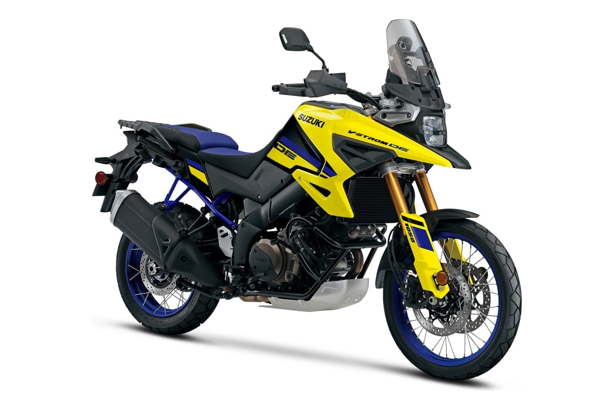 2027 Suzuki V-Strom 1050DE in Champion Yellow No. 2 and Glass Sparkle Black, front three-quarter studio view showing the beak fairing, gold fork tubes, skid plate and 21-inch spoked front wheel