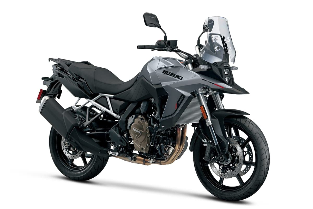 2026 Suzuki V-Strom 800 in gray, front three-quarter studio view highlighting the LED headlight cluster, beak fender and twin exhaust pipes