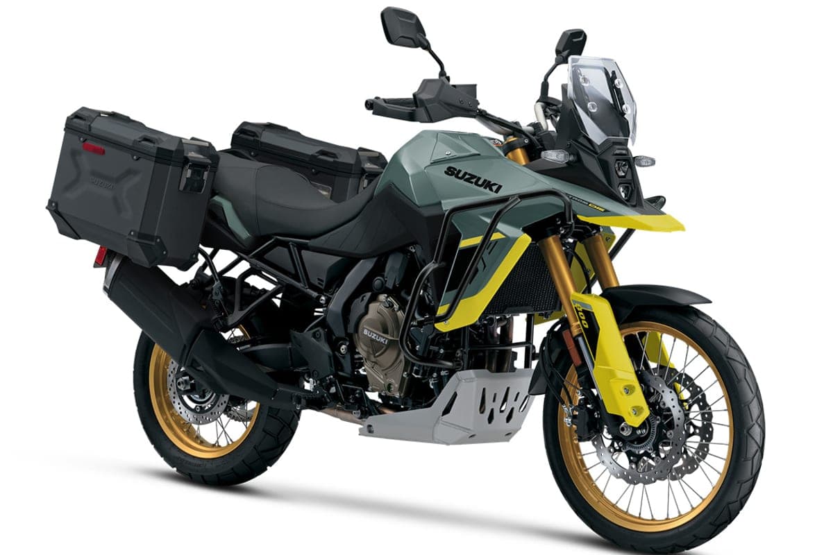 Suzuki V-Strom 800DE in grey and yellow fitted with black aluminum panniers, rear three-quarter studio shot showing the skid plate and gold wheels