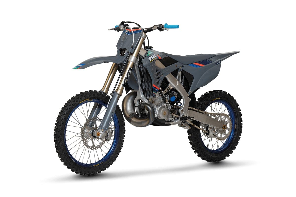 TM MX 250 FI 2T front three-quarter studio shot showing the exposed frame, curved exhaust header and blue anodized wheel hubs