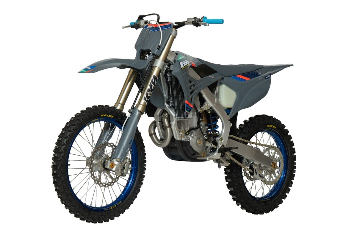 TM MX 450Fi 4T front three-quarter studio view in grey with blue graphics, showing the twin front brake rotor, radiator shrouds and blue grips
