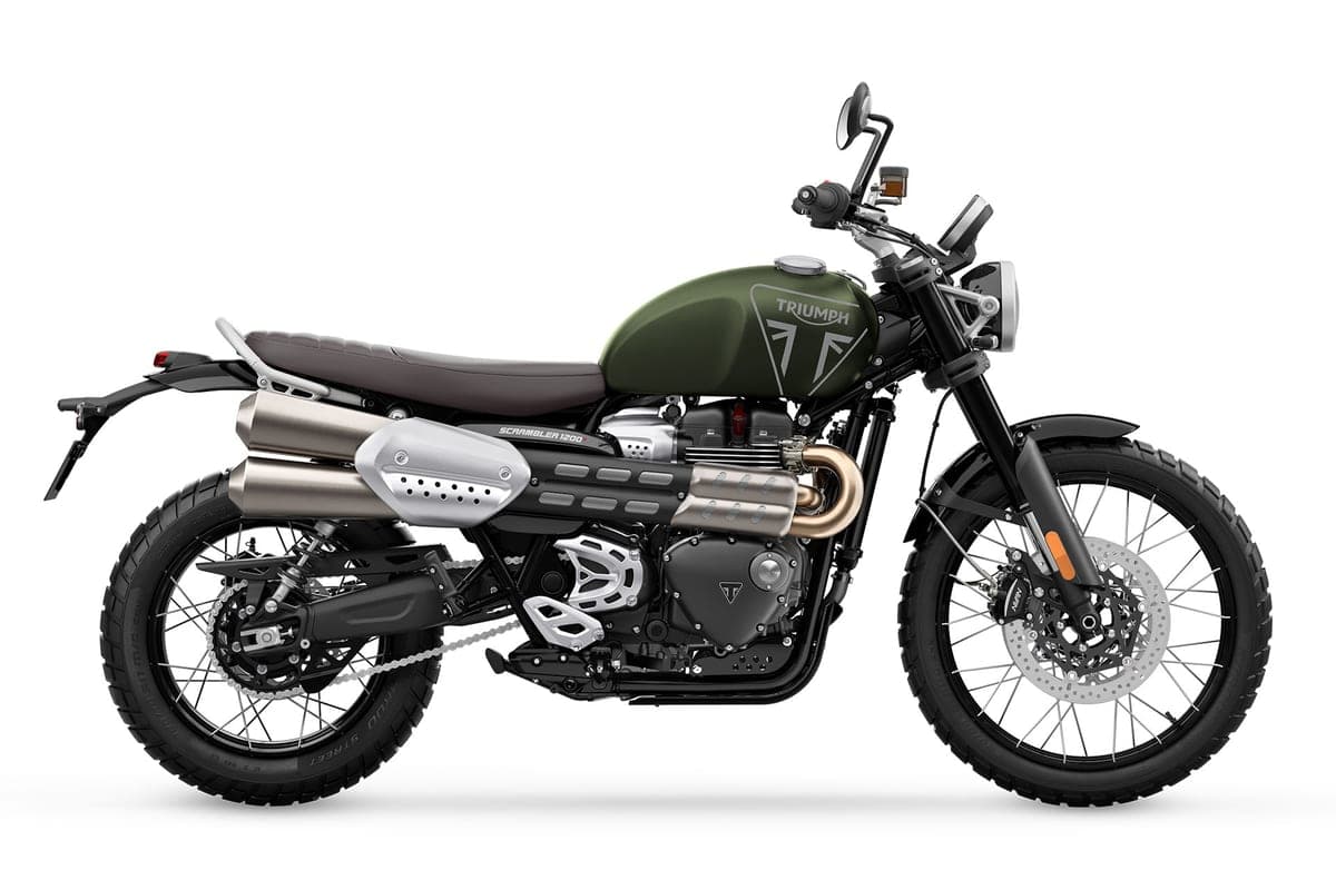 Triumph Scrambler 1200 X left-side studio profile in green and black, showing the brushed twin exhausts, engine crash bars and knobby dual-sport tires