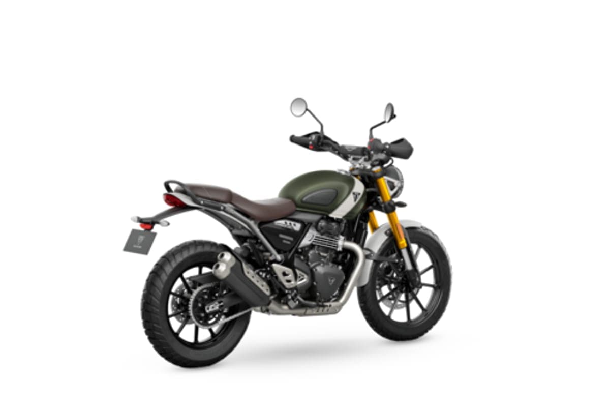 Triumph Scrambler 400 X, rear three-quarter studio shot showing the brown seat, upswept twin exhaust and rear luggage rack
