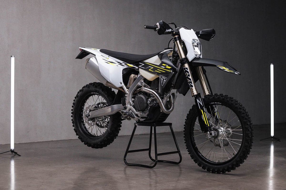 Triumph TF 450-E front three-quarter studio view highlighting the gold-coated forks, Triumph shield badge and slim white radiator shrouds